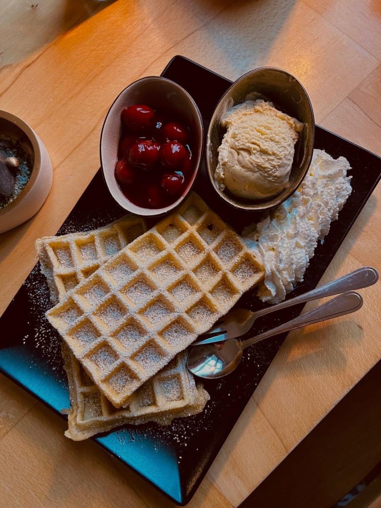 Frische Waffel mit heißen Kirschen und Vanilleeis